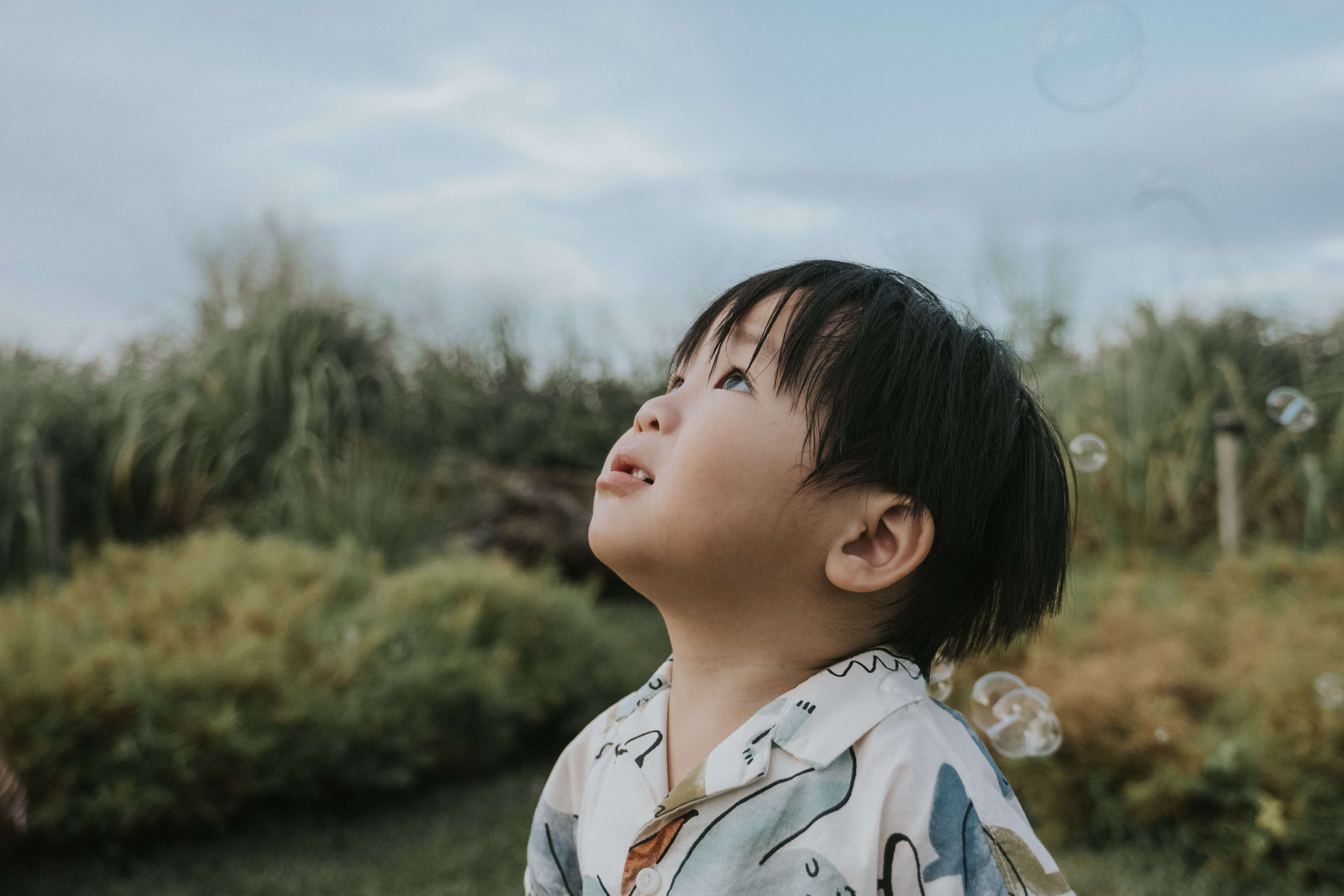 Boy watching bubbles with childlike wonder