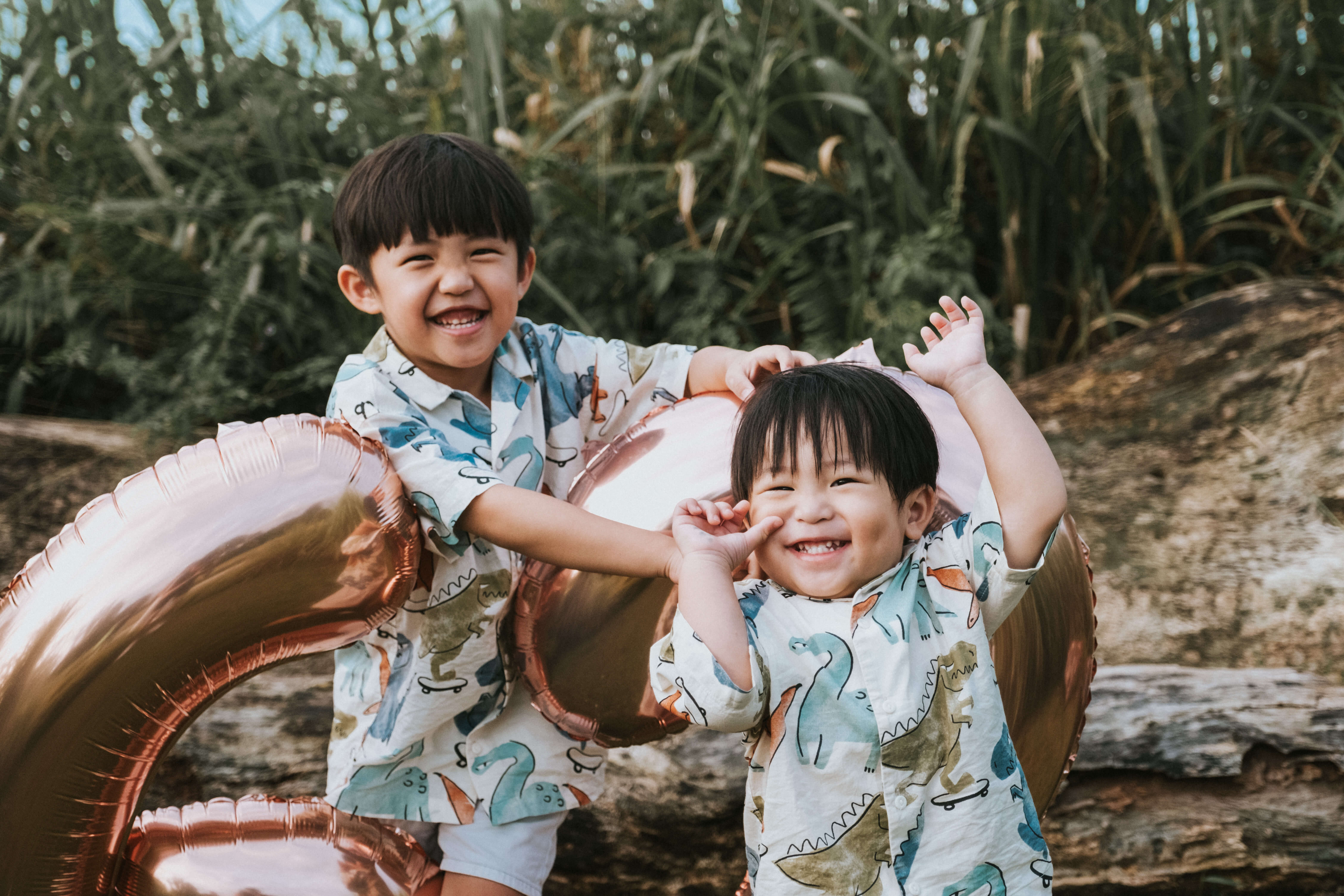 two brothers wearing matching outfit and laughing and smiling during a photoshoot